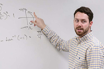 Mathematics instructor in front of whiteboard