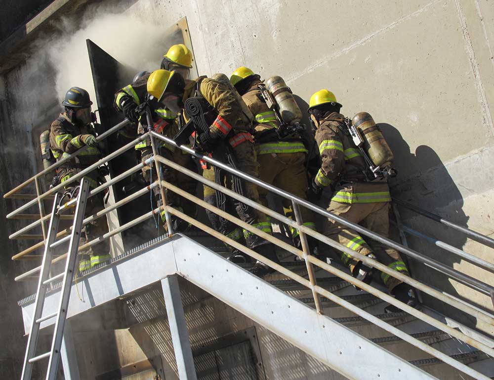 Fire Protection students ascending stairs towards smoke