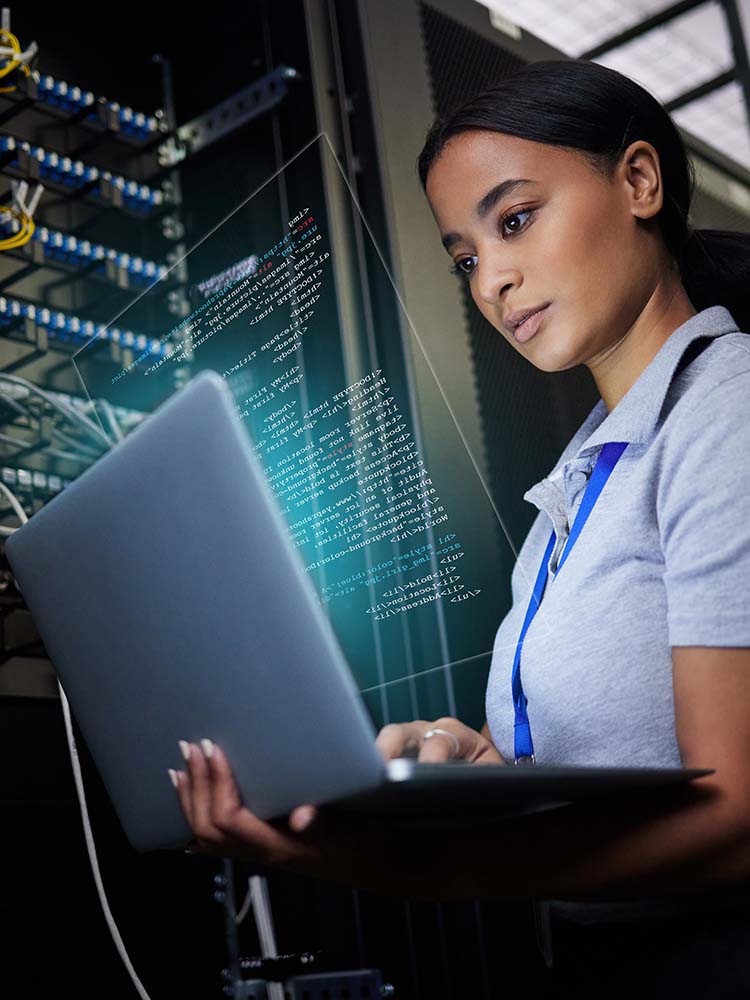 Woman with a computer by a server.