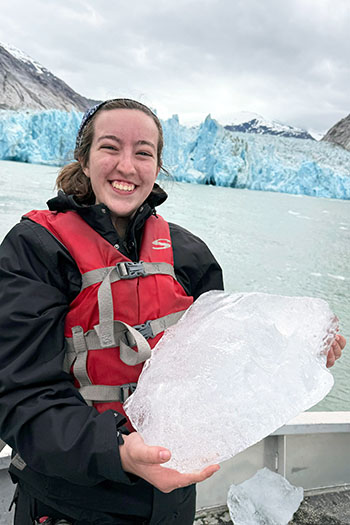 Aleah Little holding a piece of glacier on an Alaskan tour boat