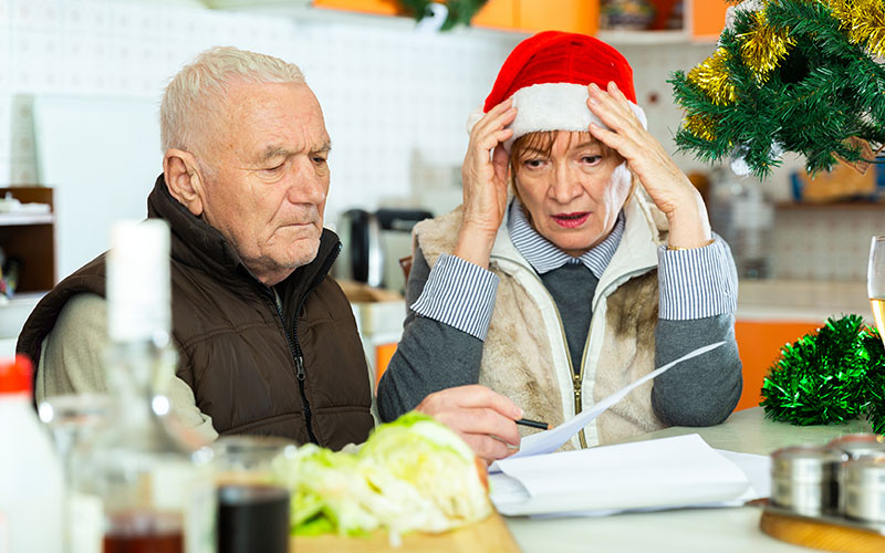 Older couple looking distressed while viewing holiday bills