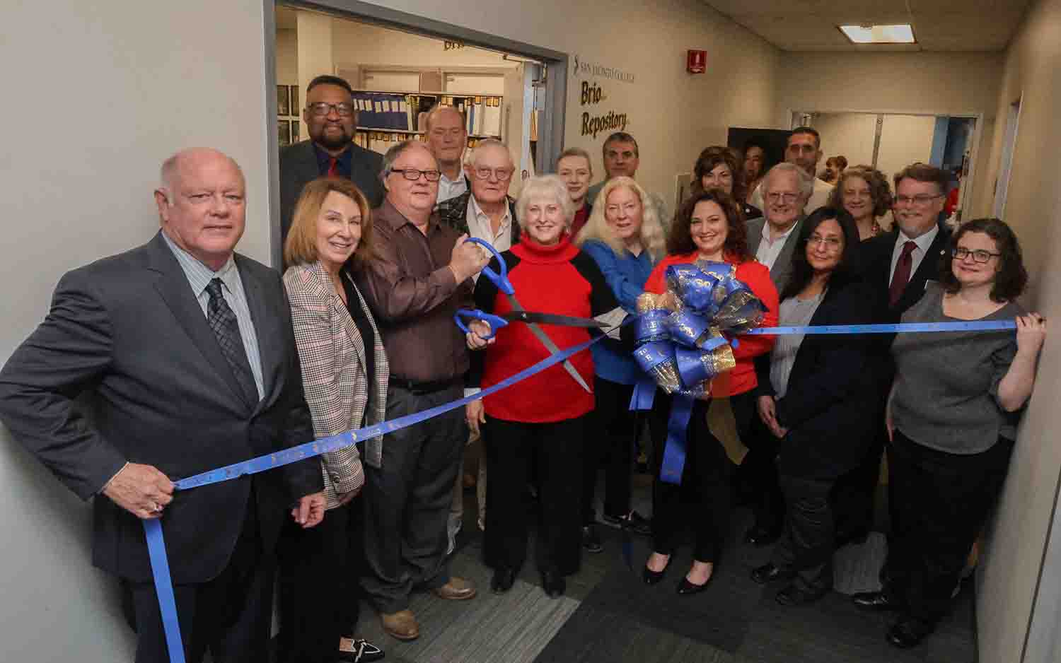 Brio Repository Ribbon Cutting large group of people cutting a ribbon