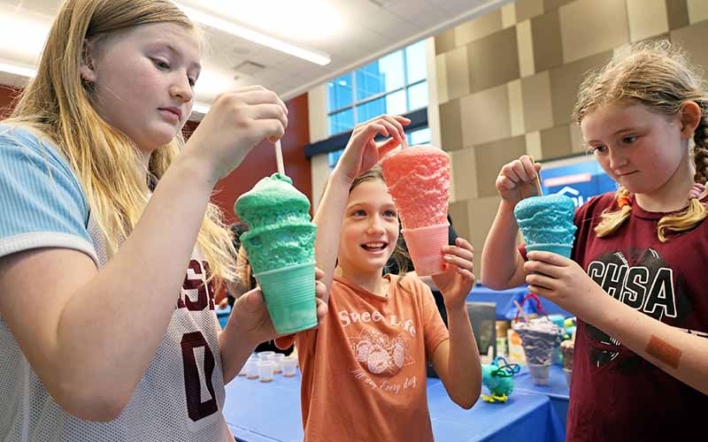 Three girls performing experiment at 2026 Mind Trekkers event